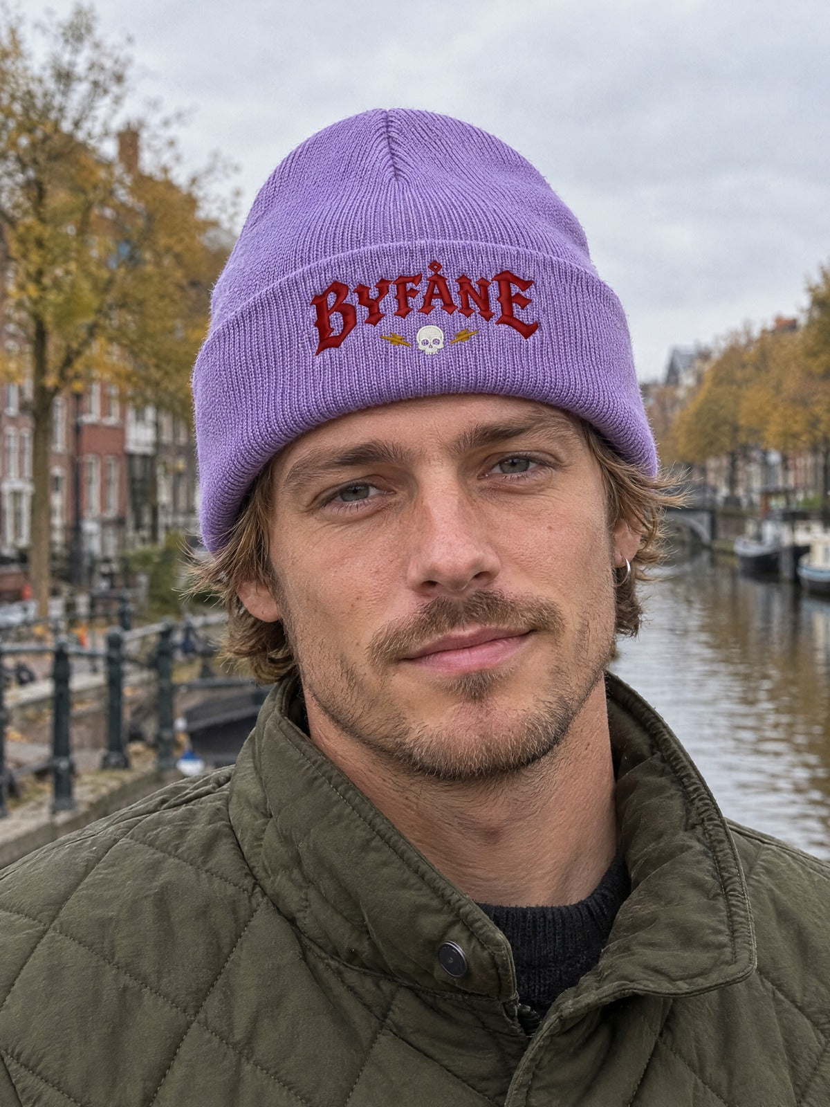 BYF PERSON 1050x463 – Byfåne, Lavendel, Hatitude Cuffed Beanie. Brodyr 10,5 × 4,63 cm.