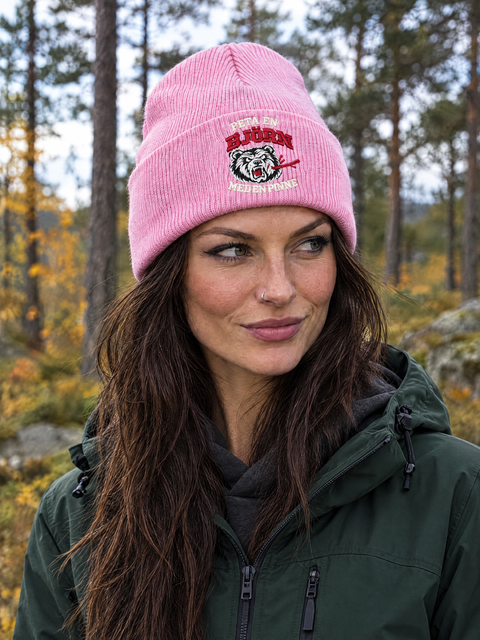 Person i skogen med rosa Peta en björn med en pinne-mössa och friluftskläder