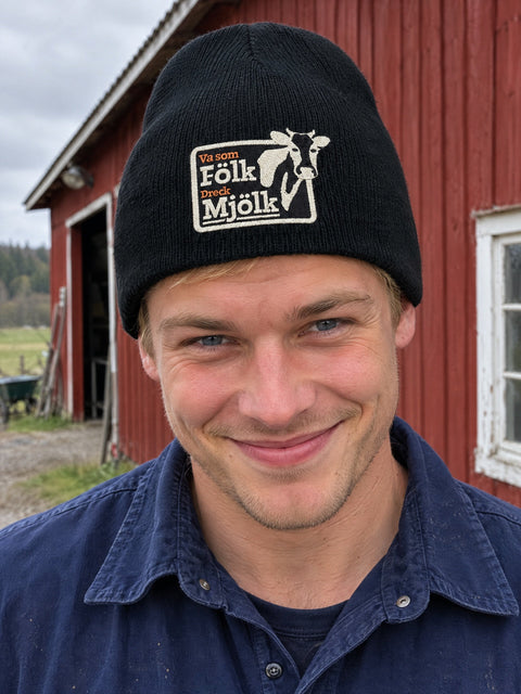 Va som Fölk Dreck Mjölk på svart Hatitude Beanie, buren av en yngre vuxen.